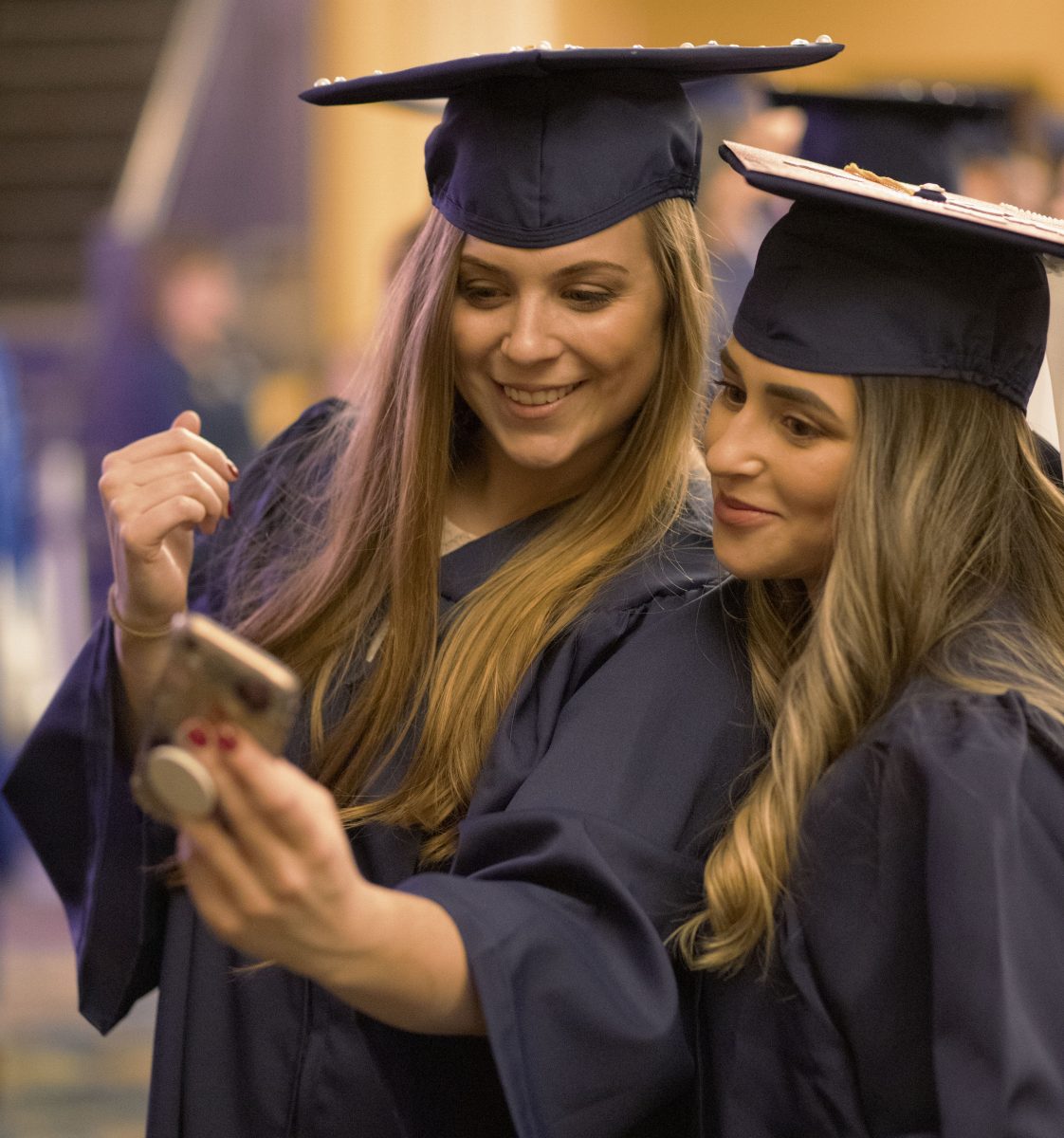 Two CEIN graduates take a selfie after their graduation ceremony.